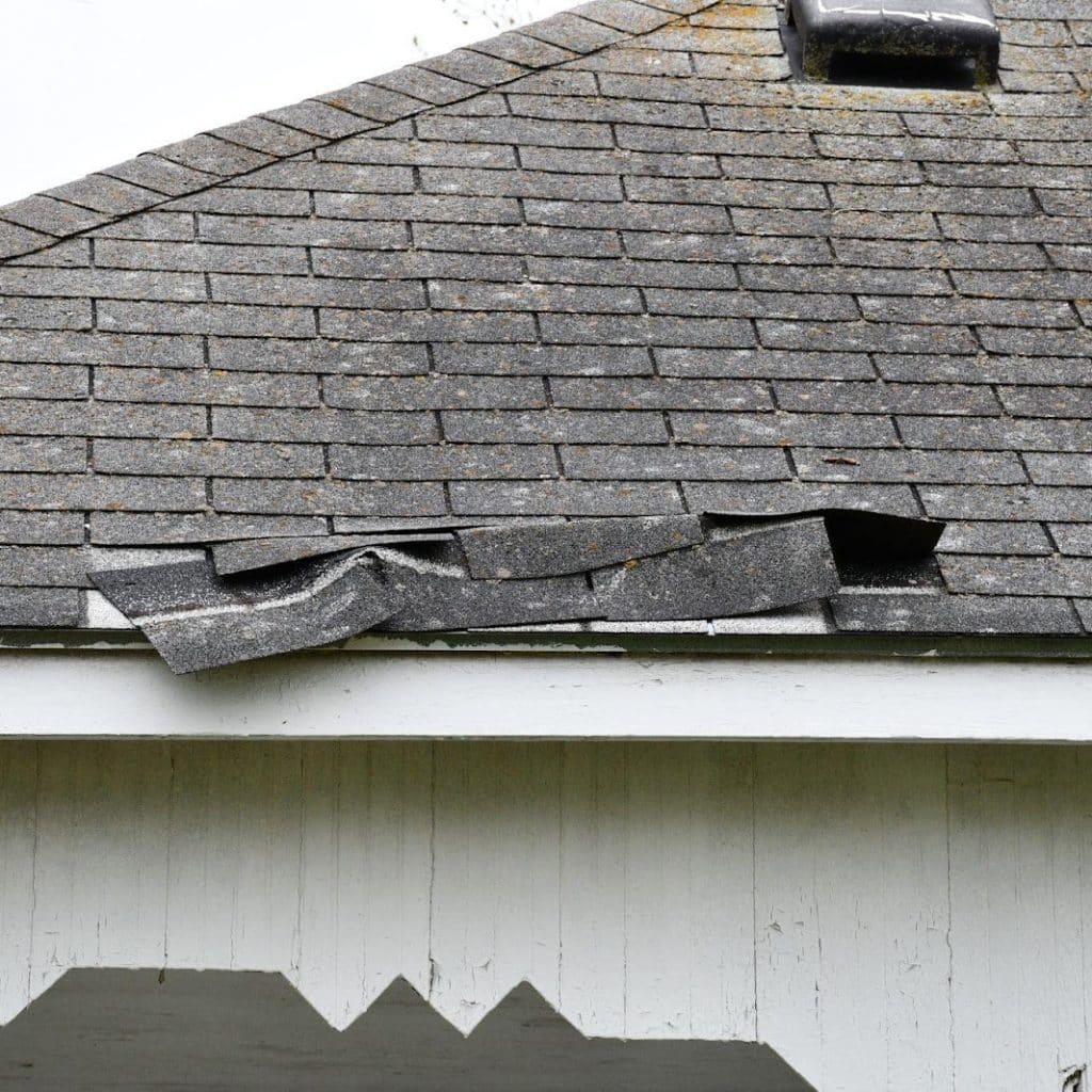 A roof with a noticeable hole and shattered window, highlighting deterioration and disrepair